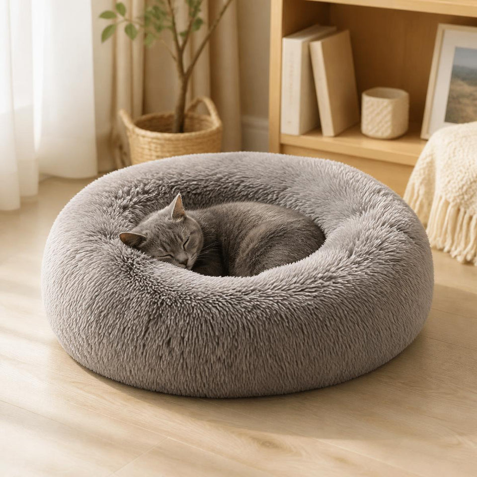 Grey cat curled asleep in a grey Cudli calming donut pet bed